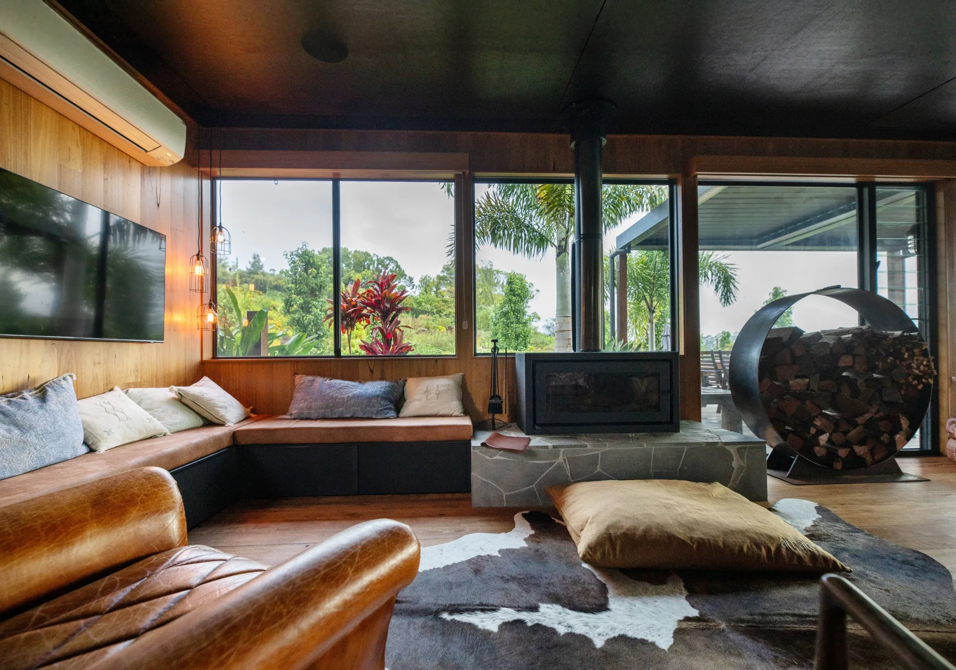 A lounge space with a wood heater and banquette bench at Amaroo Bangalow
