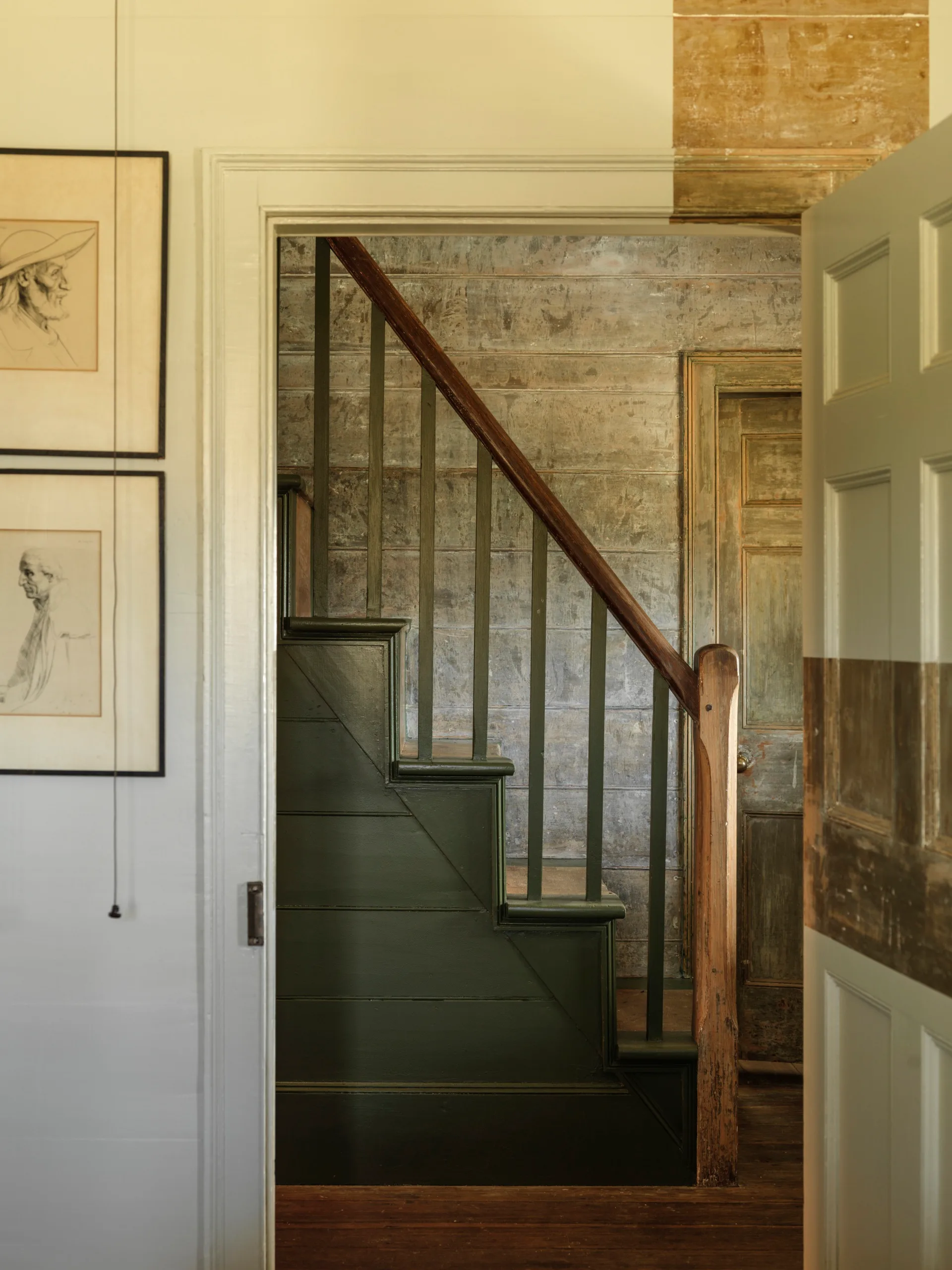 A timber staircase painted dark green