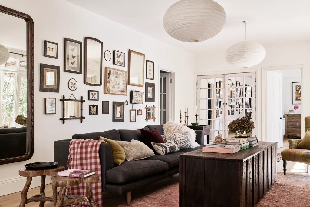 A lounge room with a gallery wall, timber coffee table and lantern pendant lights