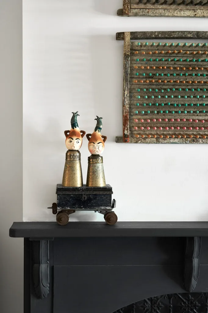 A black fireplace with a vintage trinket on the mantle
