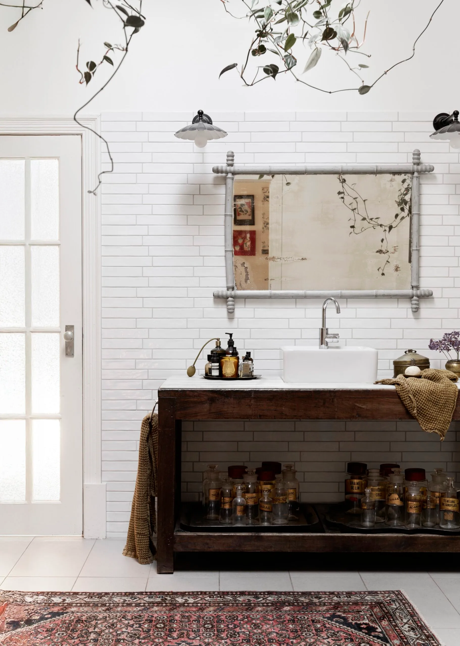 A white bathroom with a timber vanity and a pink rug