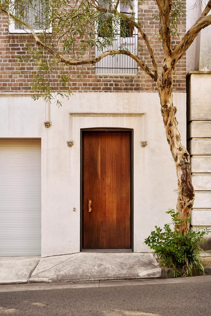 A render and brick facade with a timber door