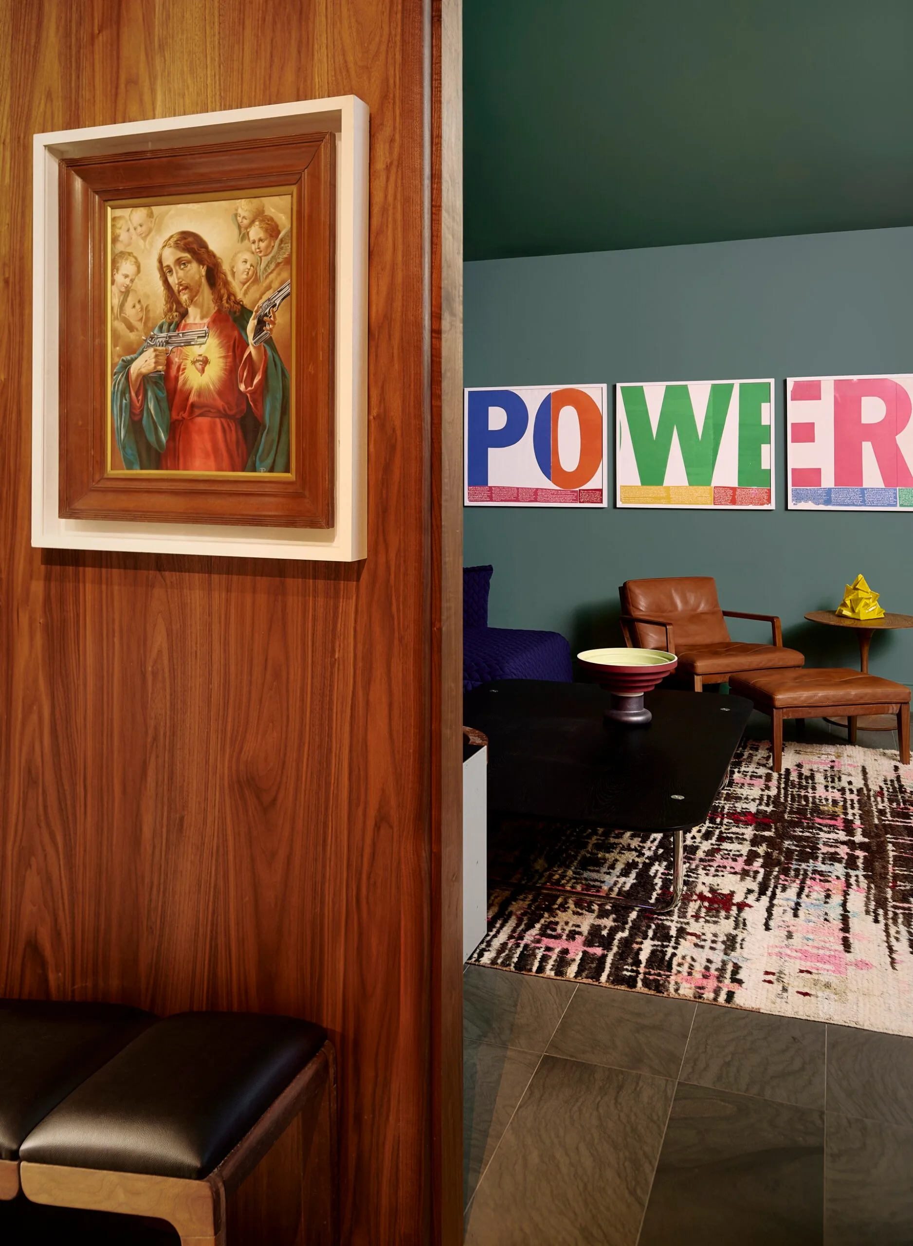 A green sitting room with framed artworks