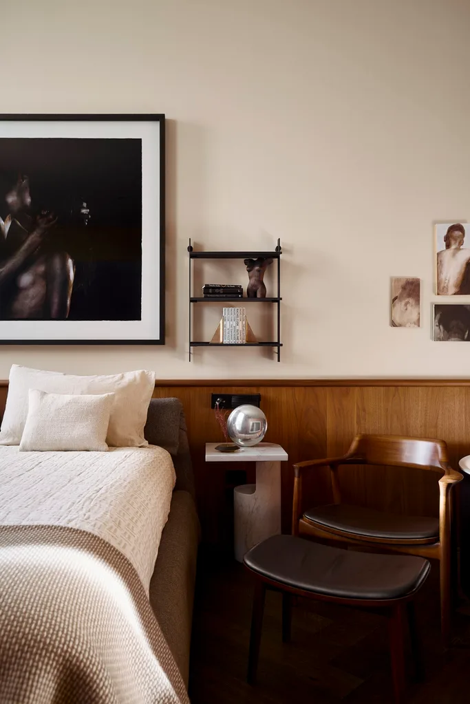 A modern, neutral-toned bedroom with timber panelling
