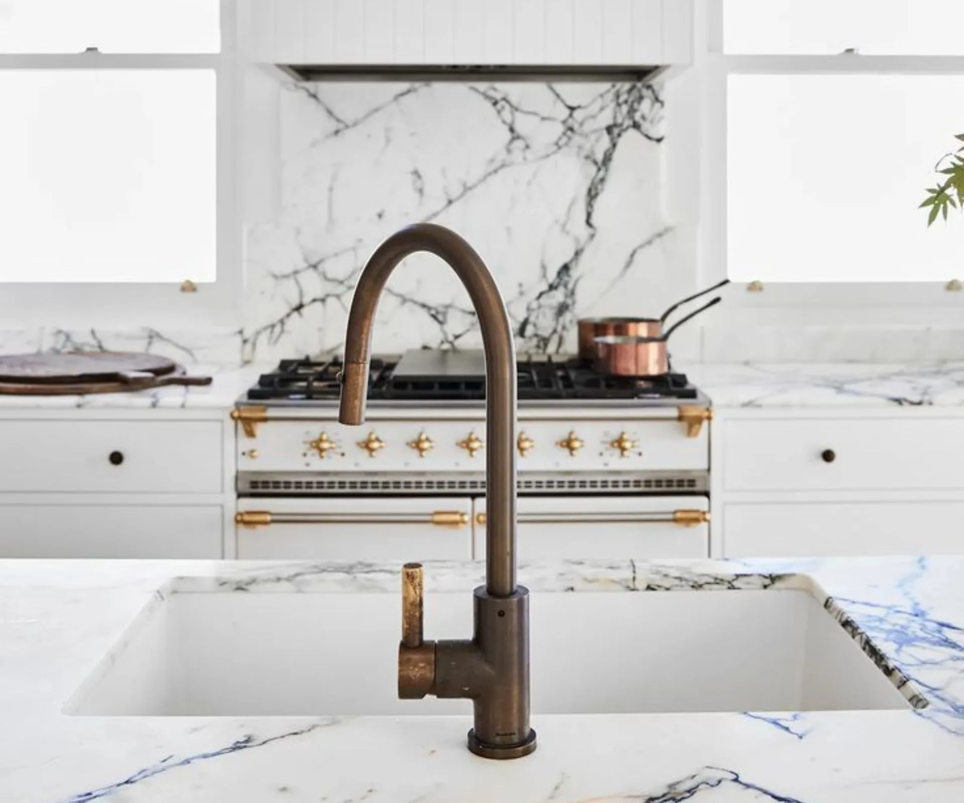 Brass tapware in white and stone kitchen