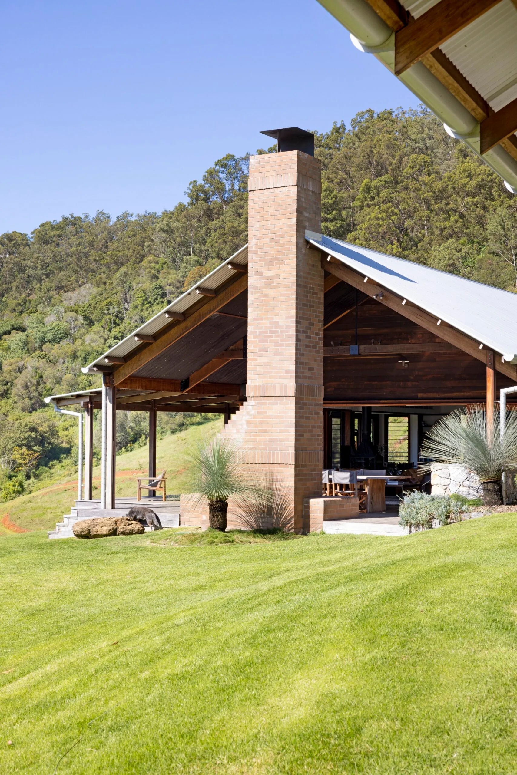 An A-frame home with outdoor living area and fireplace