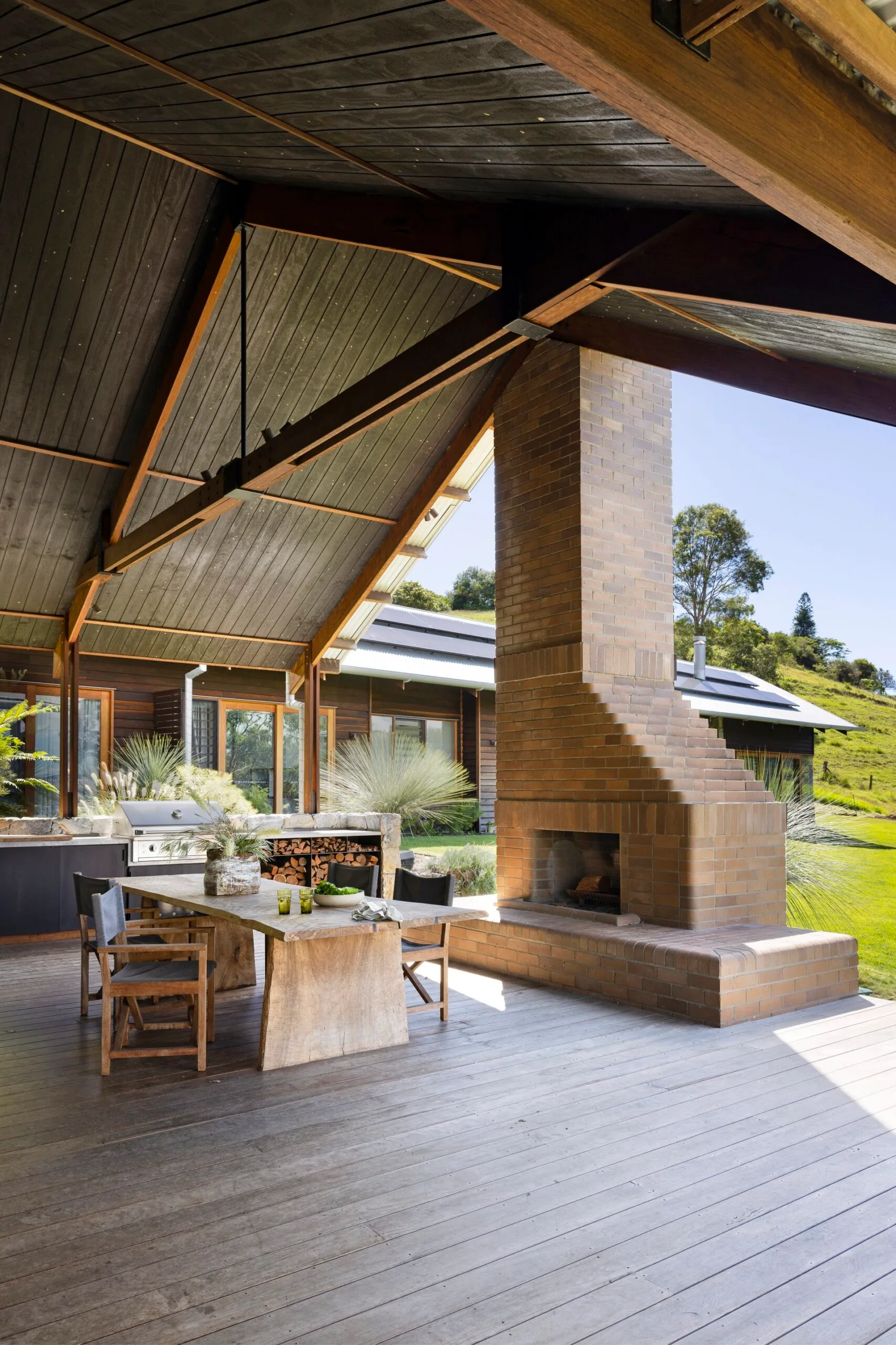 An outdoor living area featuring a pitched roof and log fire.