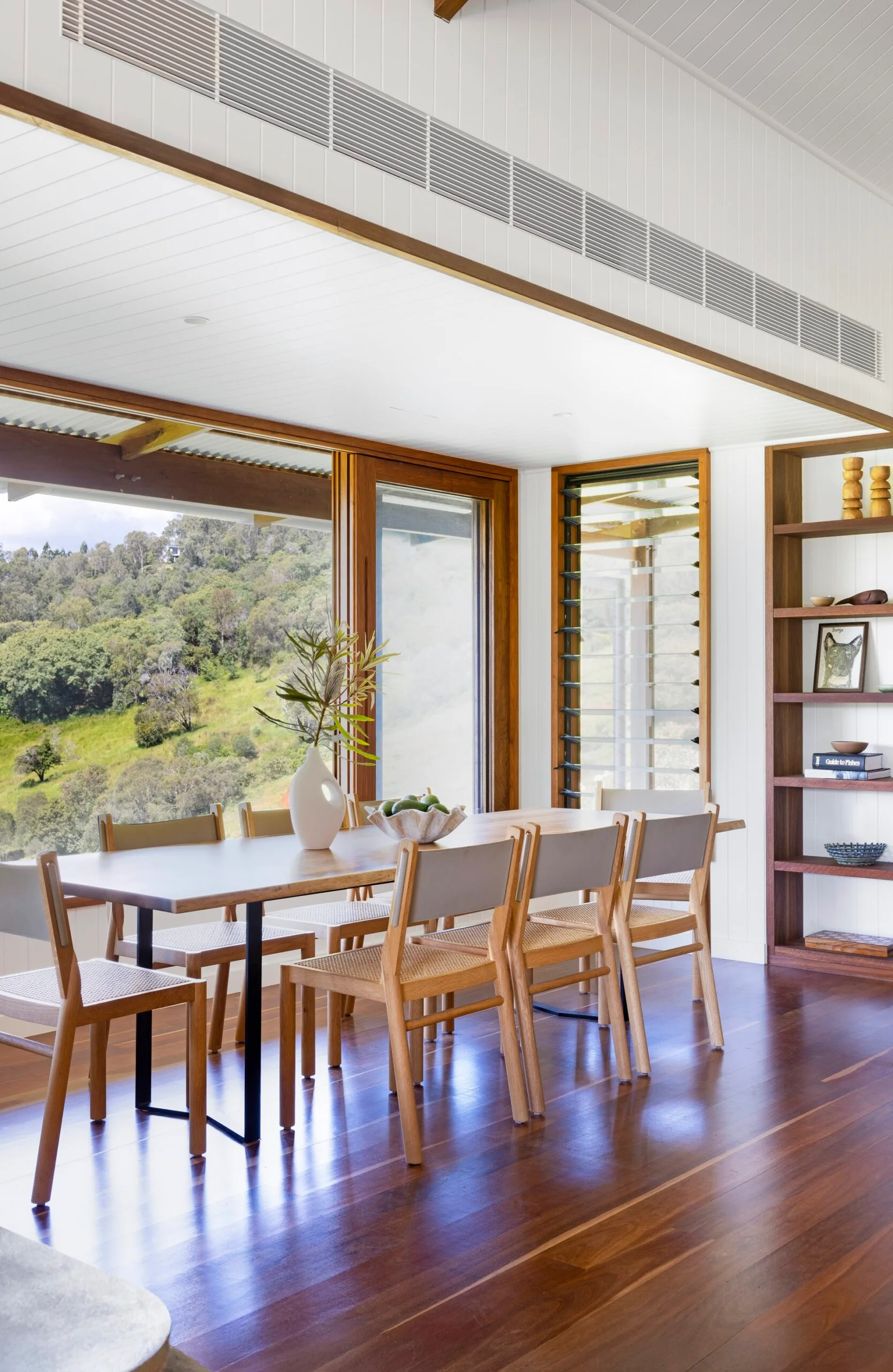An open plan dining room with windows opening out towards the outdoors