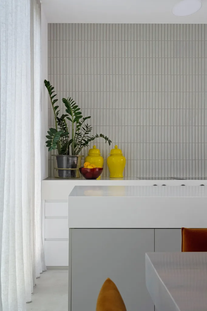 White and grey kitchen with bright yellow jars