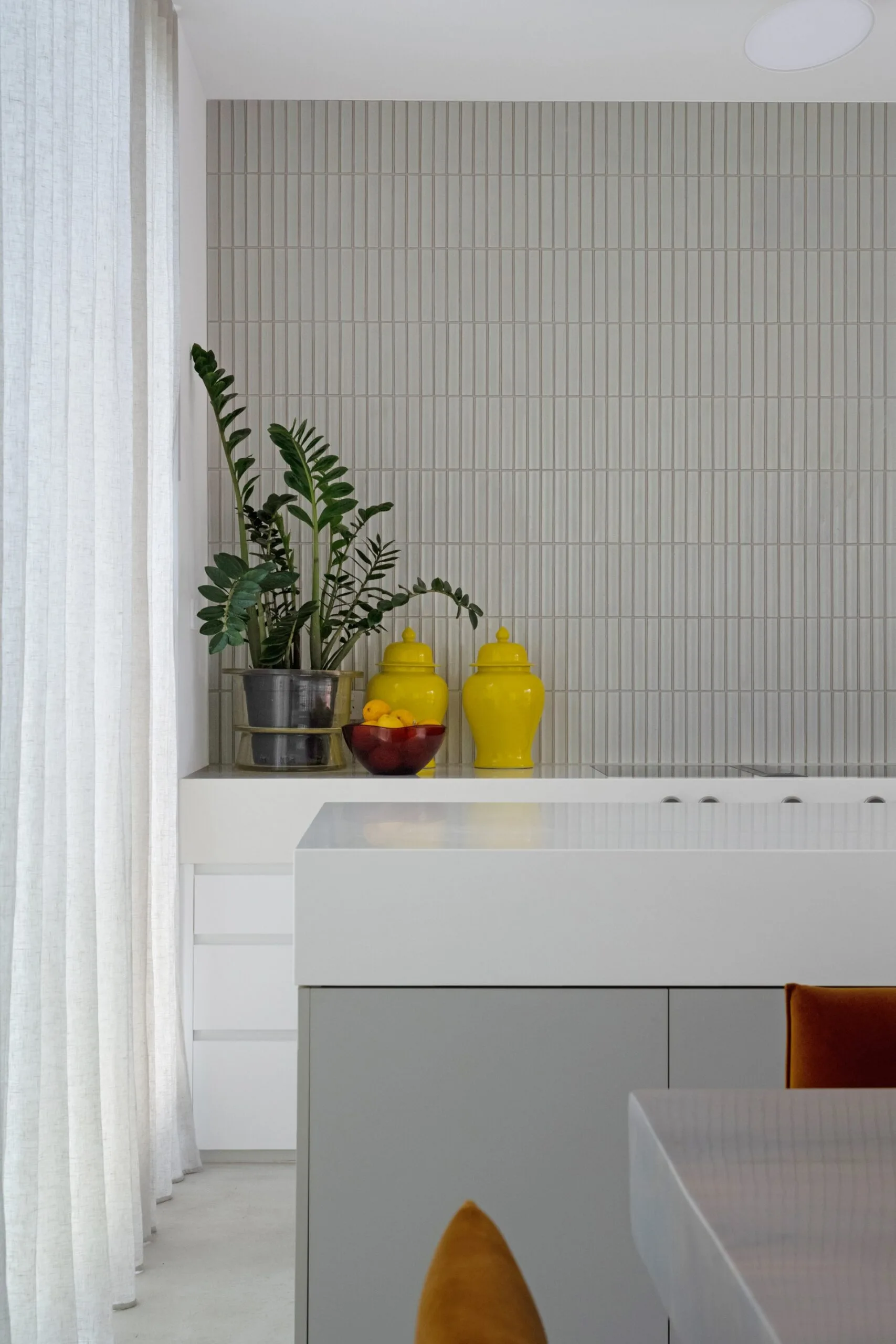 White and grey kitchen with bright yellow jars
