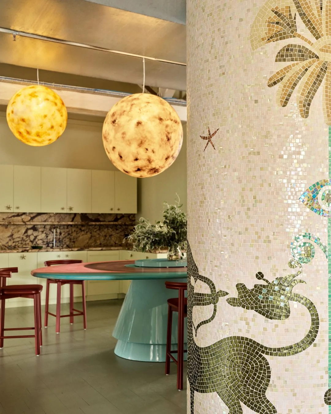 A glass mosaic with ocean motifs wraps around the wall that separates the kitchenette from the rest of the Alemais office. 