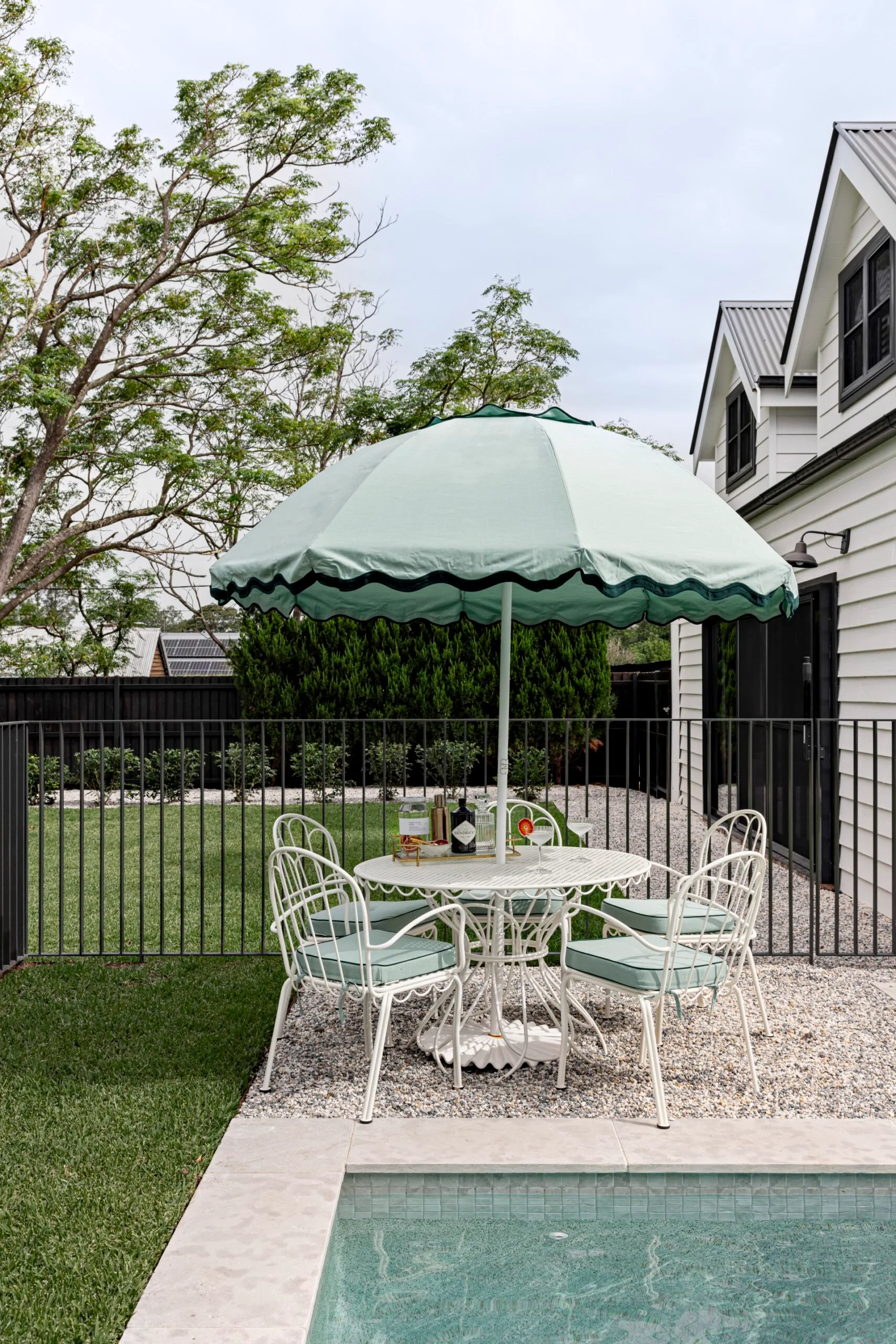 A mint green outdoor setting by a pool.