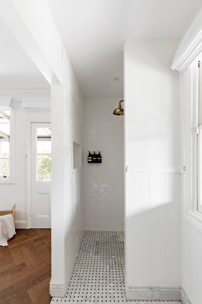 A white tiled ensite with copper shower fitting