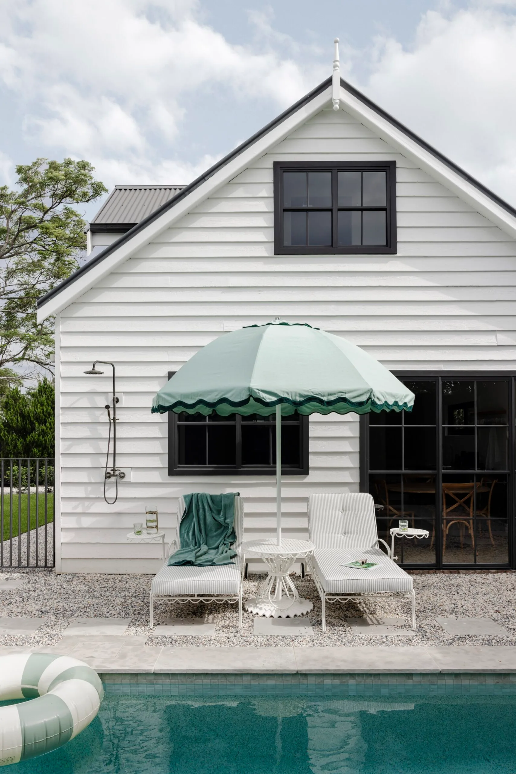 Palm Springs-inspired magnesium pool with mint green sungloungers and umbrella