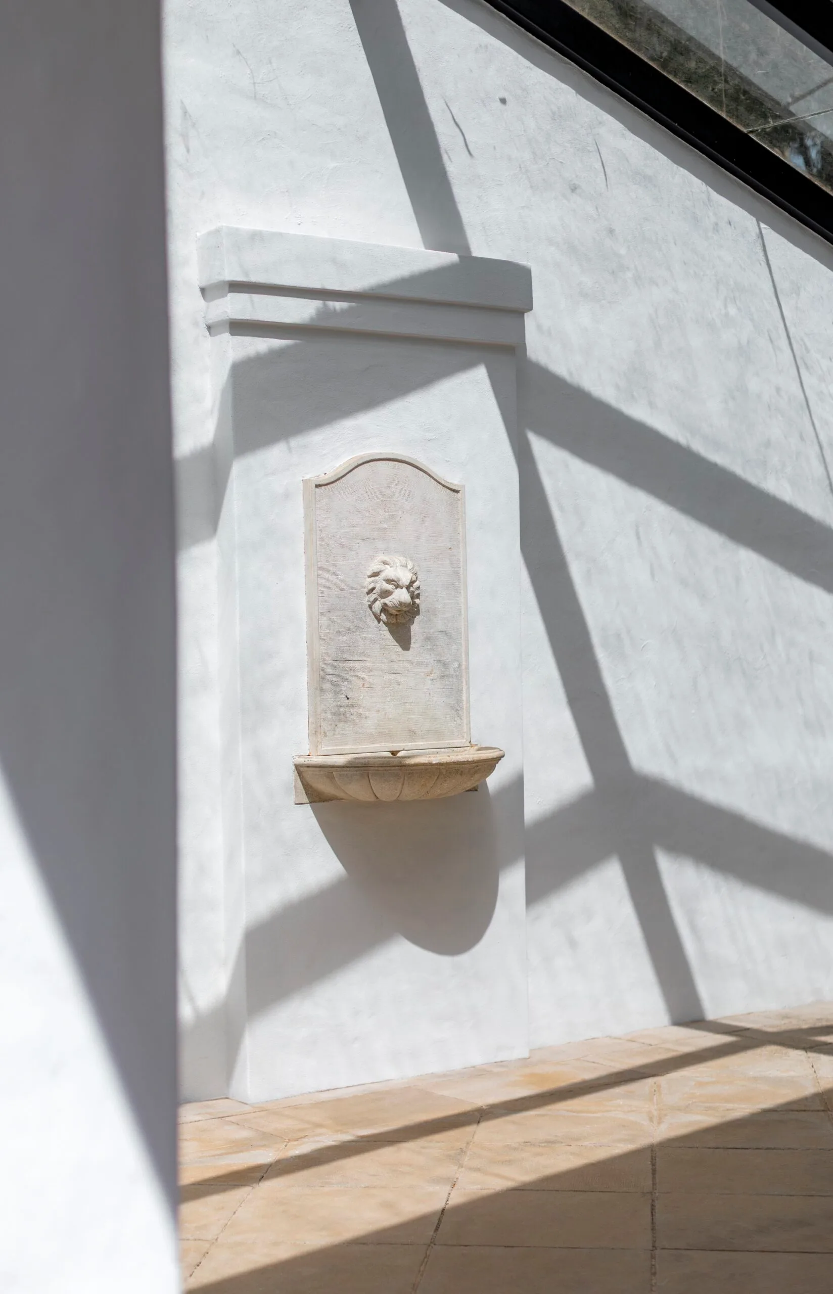 A white wall with a mounted fountain