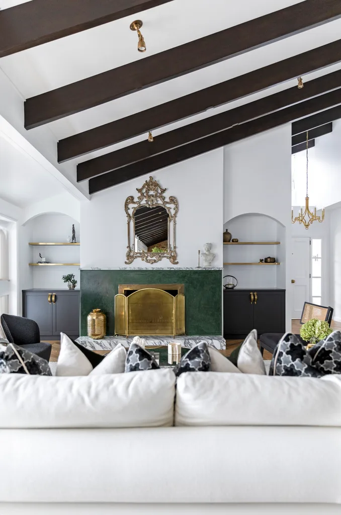 A spacious living space with a green fireplace and gold finishes