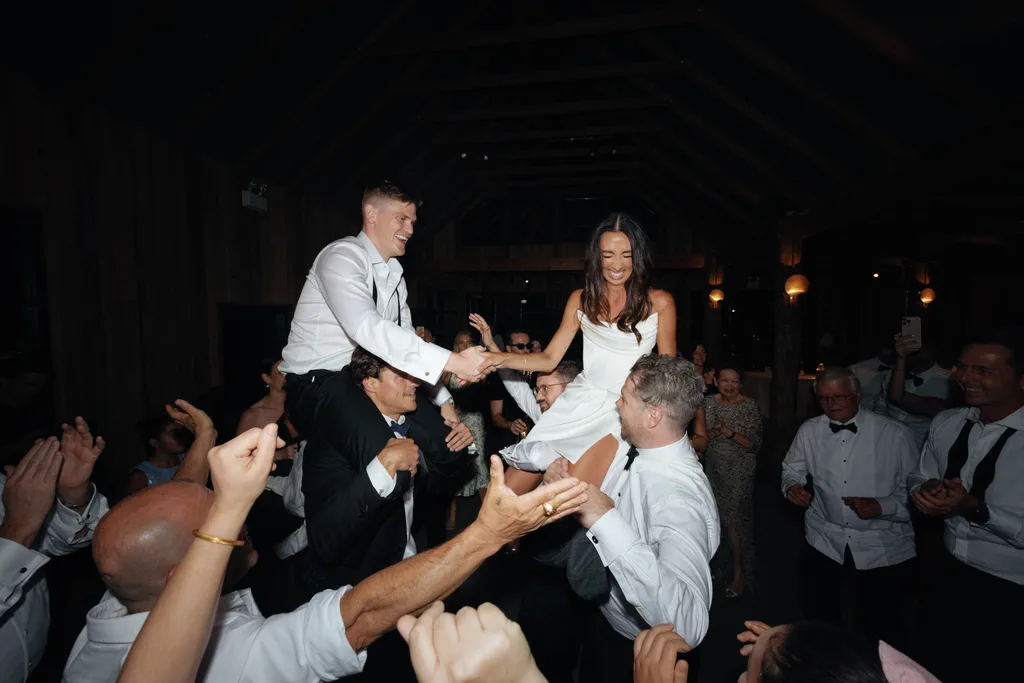 A newlywed couple dance with friends at their reception.