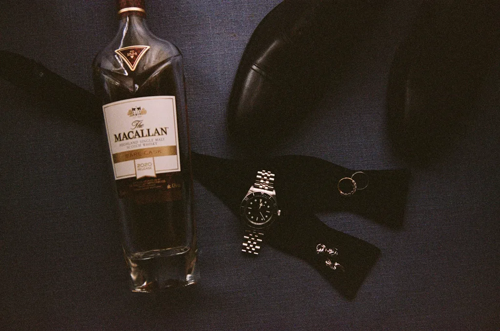 A groom's whiskey, watch, shoes and wedding bands