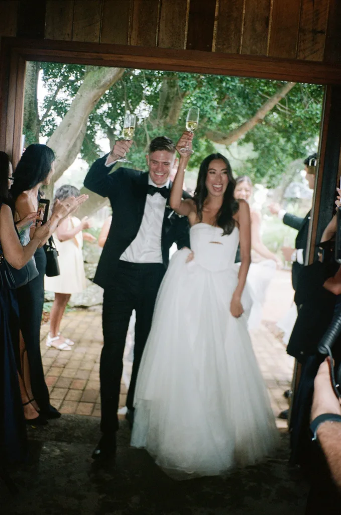 A newlywed couple enter their reception venue