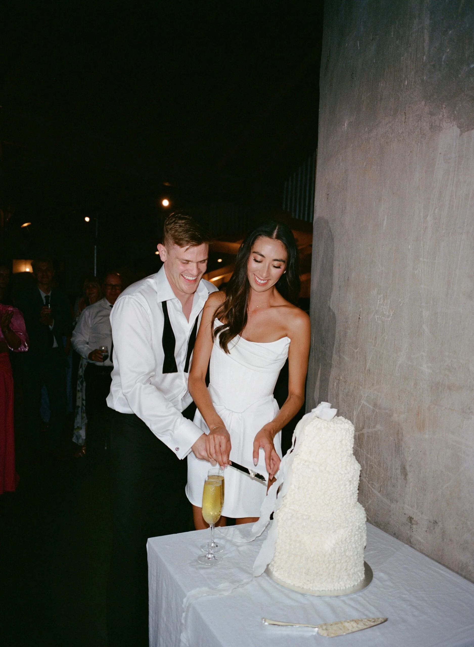A newlywed couple cut their wedding cake