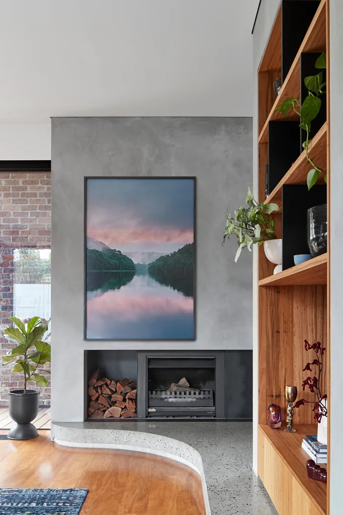Fireplace and large artwork in modern home. Belle