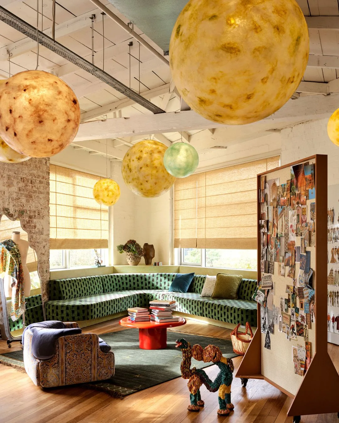 At the new Al&eacute;mais Sydney HQ, round moon-like pendant lights hang nestled into the tip of the wing-shaped floor plan over the built-in seating area. 