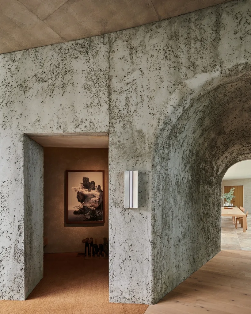 Textured concrete hallway with artwork and dining area visible.