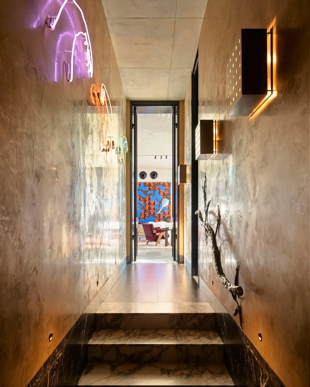 Bronze hallway with marble tiles and neon pendants on the wall.