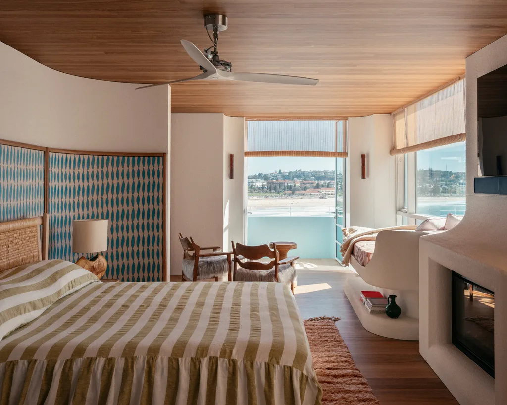 Modern bedroom with striped bedding, natural wood accents, beach-themed decor, ocean view. Belle interior design awards Richards Stanisich.