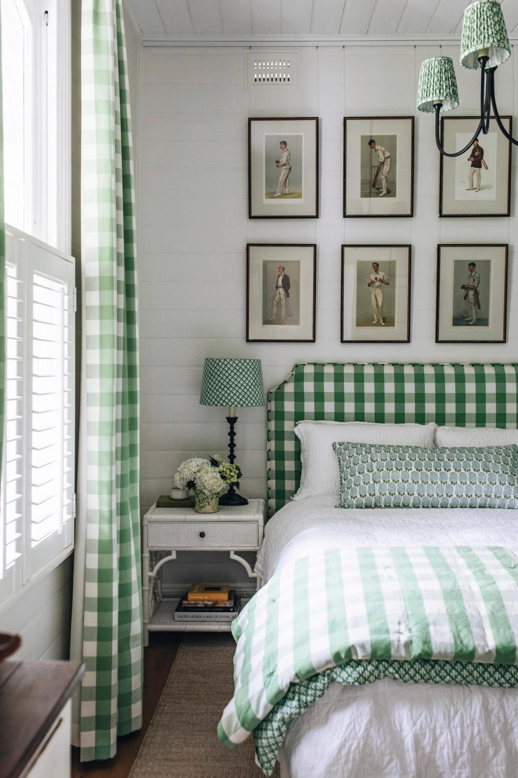 A bedroom with green gingham accents and a gallery wall