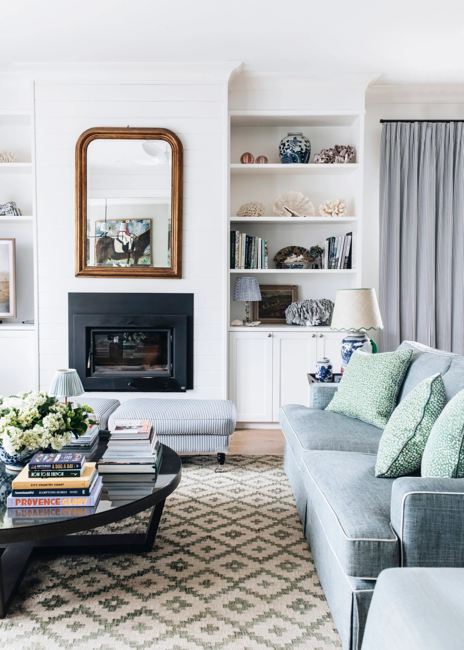 A country living room with a fireplace white walls and blue and grey sofas
