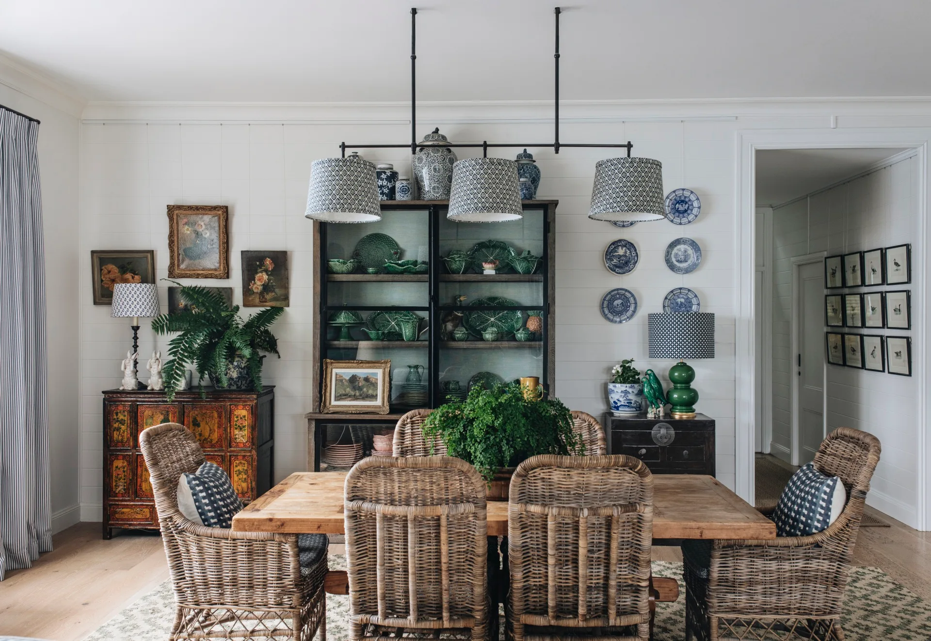 A country dining room with a timber dining table and a cabinet full of cabbageware