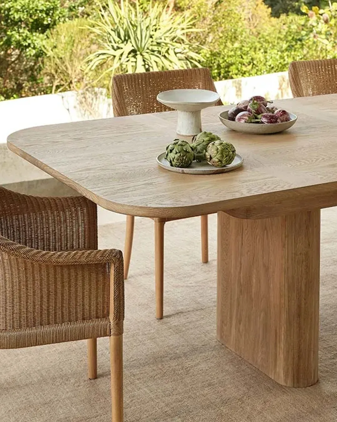 Natural oak dining table set shown outside from Coco Republic. 
