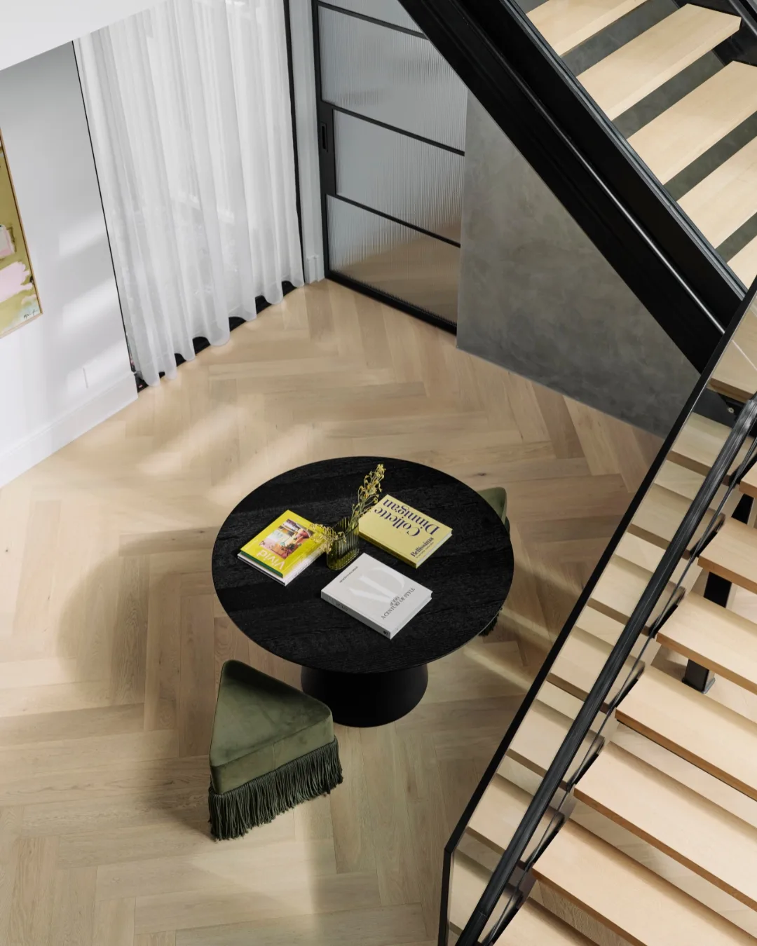 A bird's eye view of a living area with herringbone engineered timber flooring, a black round dining table and green velvet tasseled stool. 