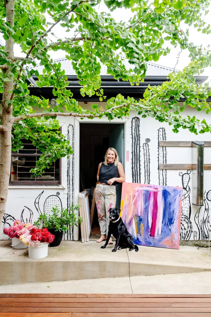 Artist Madi Young outside her studio with her dog