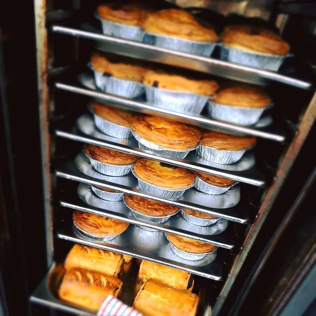 A stack of pies and sausage rolls from Orange Pie Company