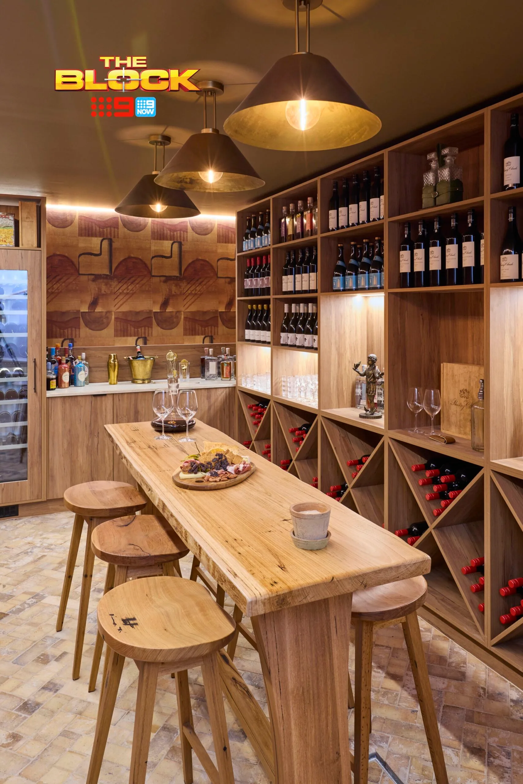 An underground wine cellar with timber shelving on The Block