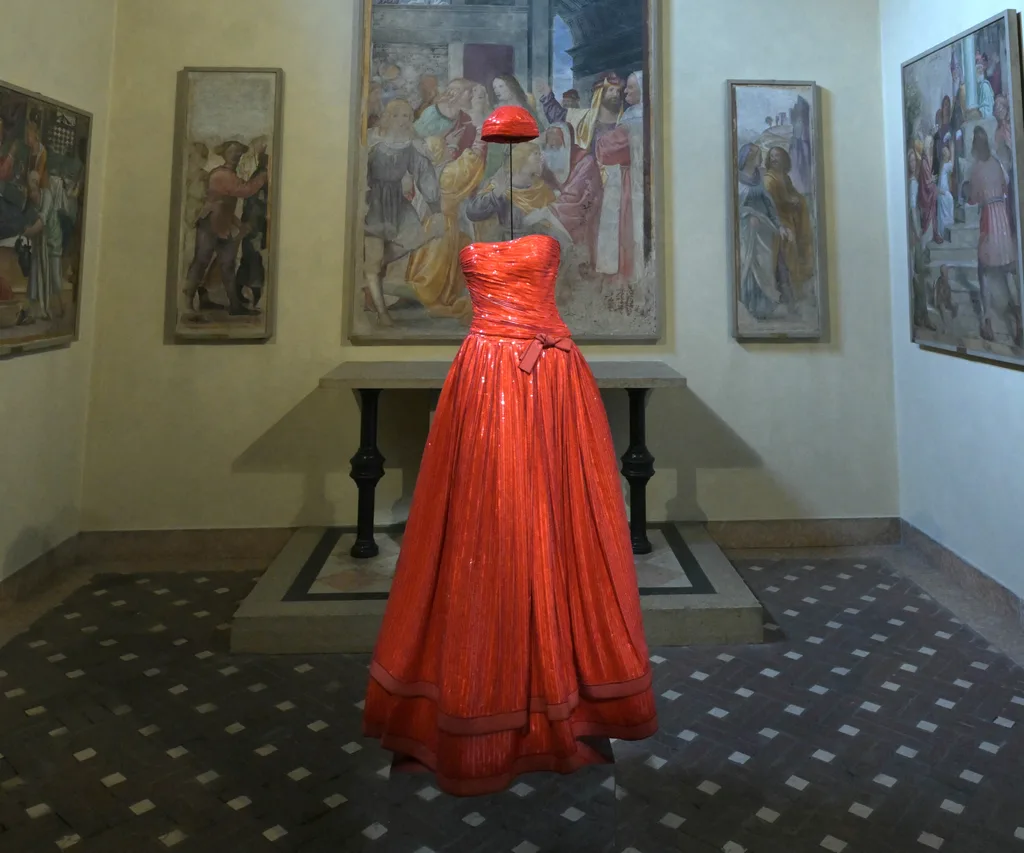 A gallery room with a red dress and floating red hat