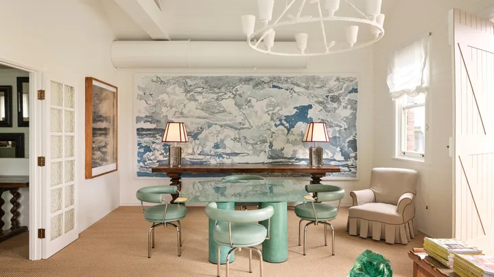 A timber desk, blue and white pattern wallpaper, Turquoise armchair, timber lamp with paper lampshade, vintage artwork in the Tamsin Johnson studio