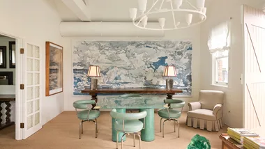 A timber desk, blue and white pattern wallpaper, Turquoise armchair, timber lamp with paper lampshade, vintage artwork in the Tamsin Johnson studio