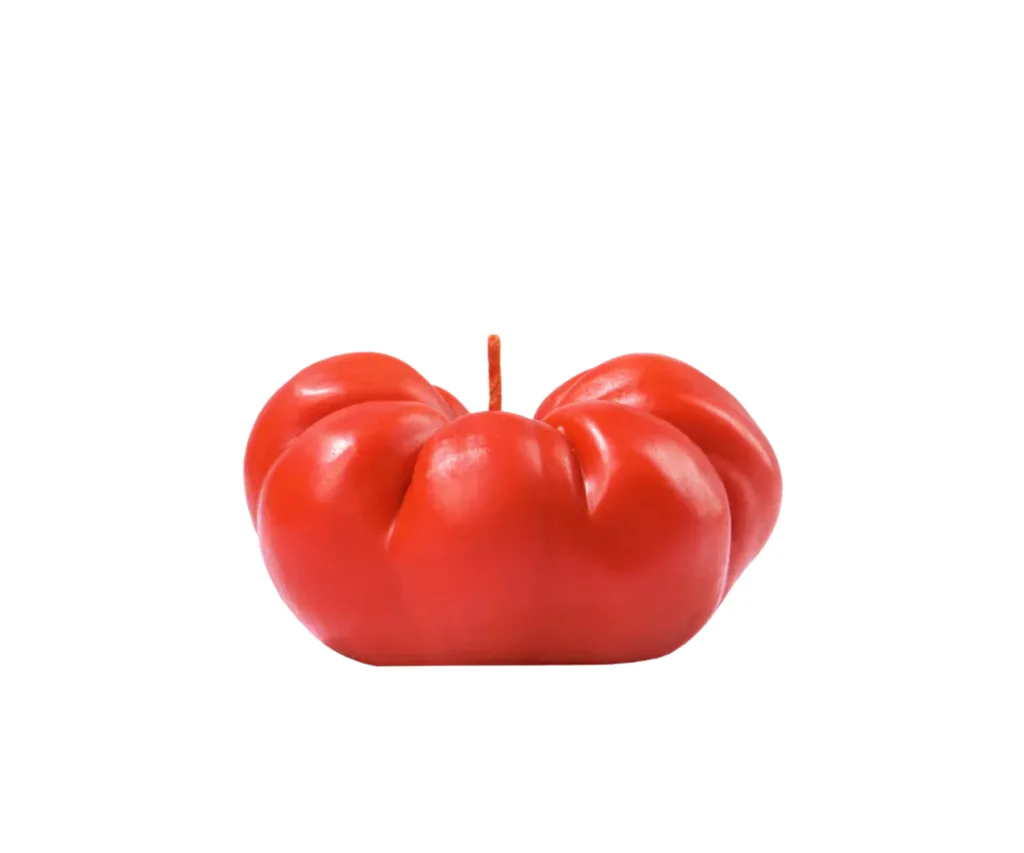 A red candle shaped like a tomato