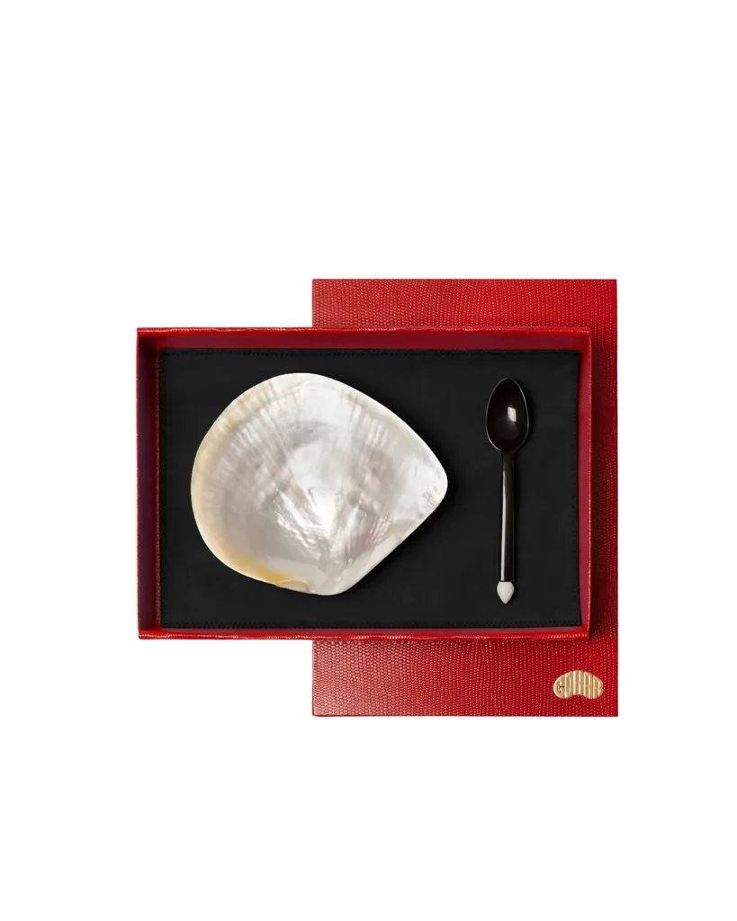 A red box with pearl caviar serving dish and spoon