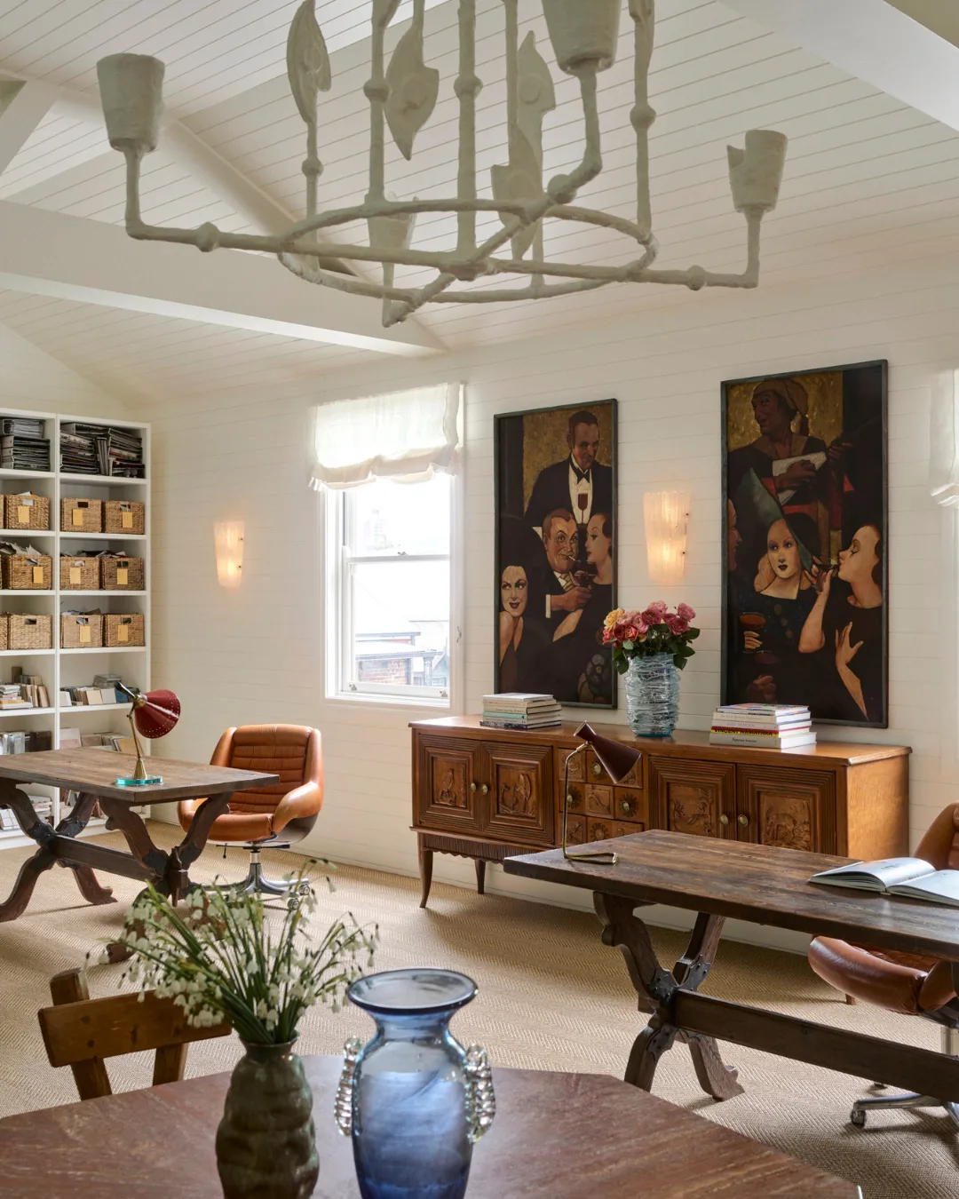 A timber sideboard, abstract art, ceramic chandelier, leather armchair and bookshelf
