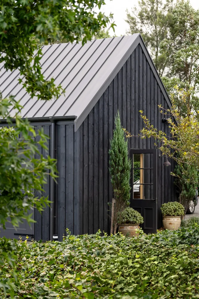 Black shed with surrounding garden