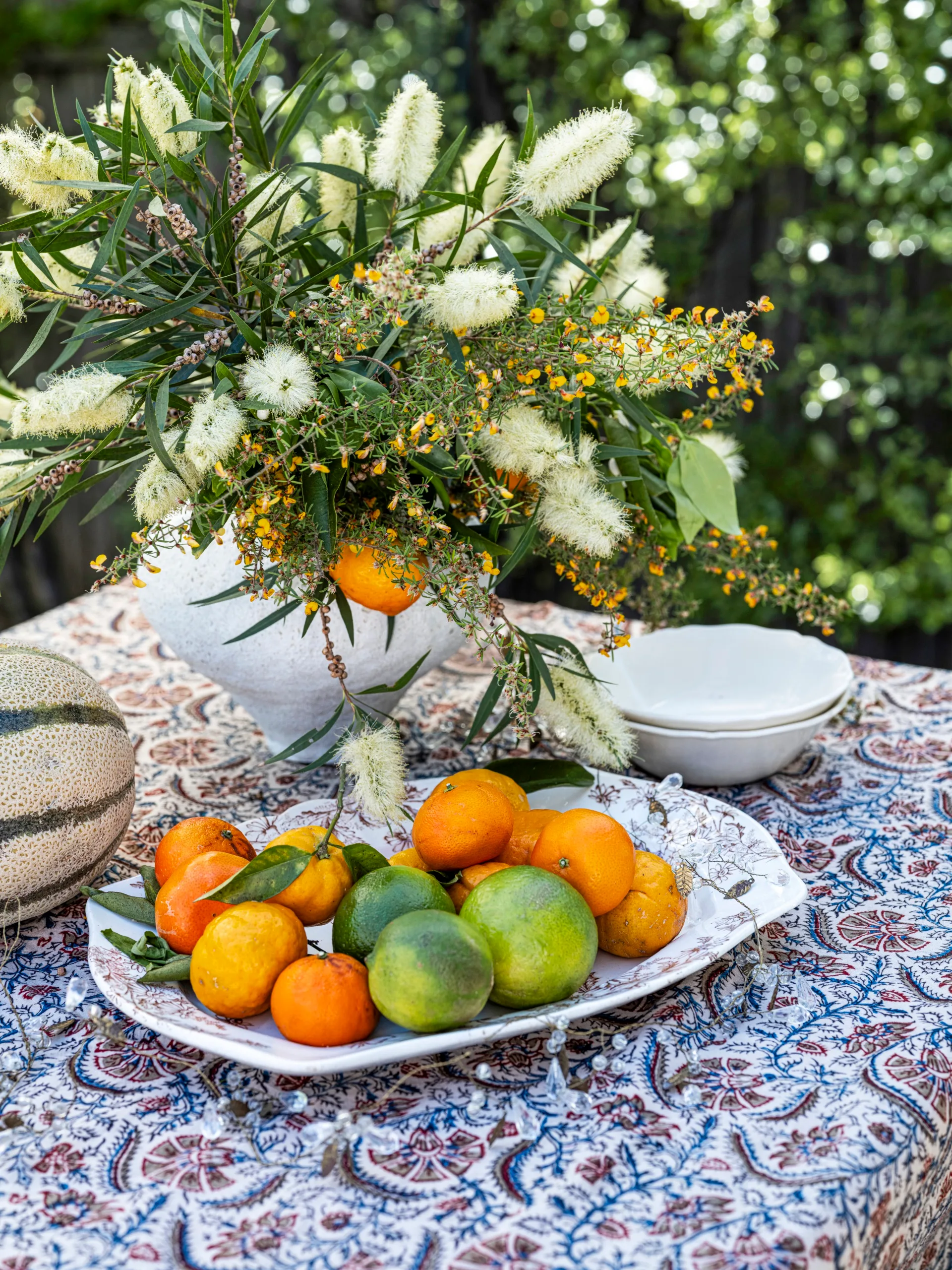 A native bouquet, fruit and an ornate tablecloth