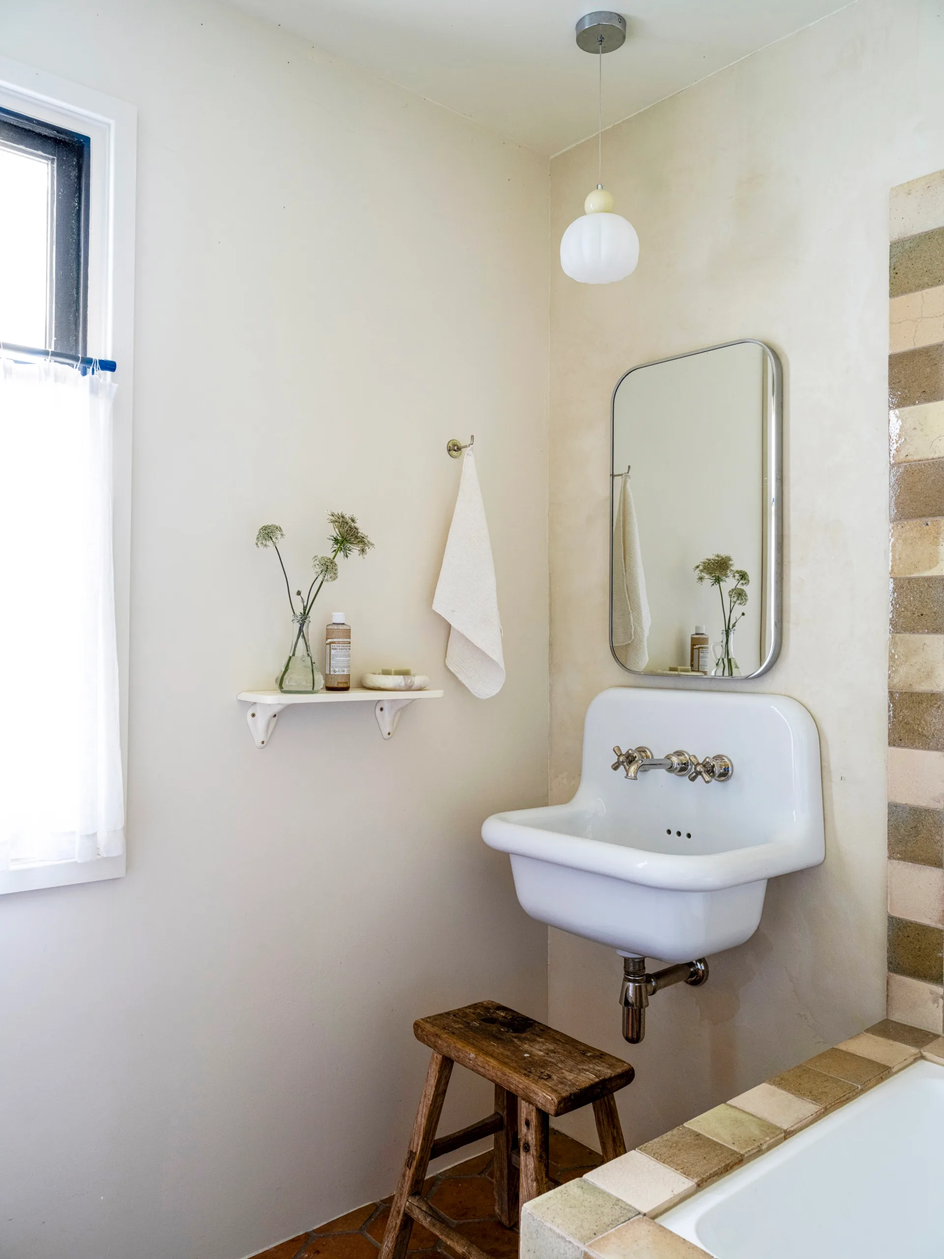 A rustic bathroom featuring a vintage-style sink and tapware