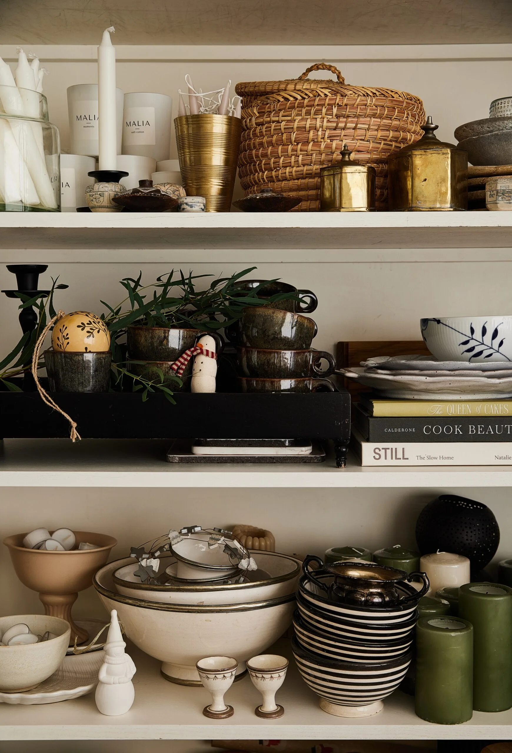 A close up of shelves stacked with crockery and Christmas decorations