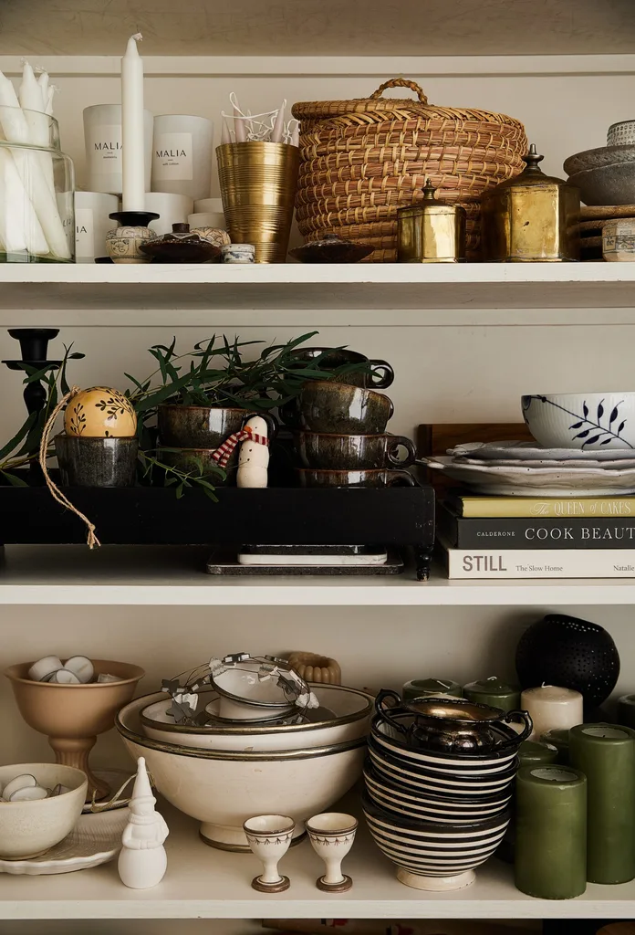 A close up of shelves stacked with crockery and Christmas decorations