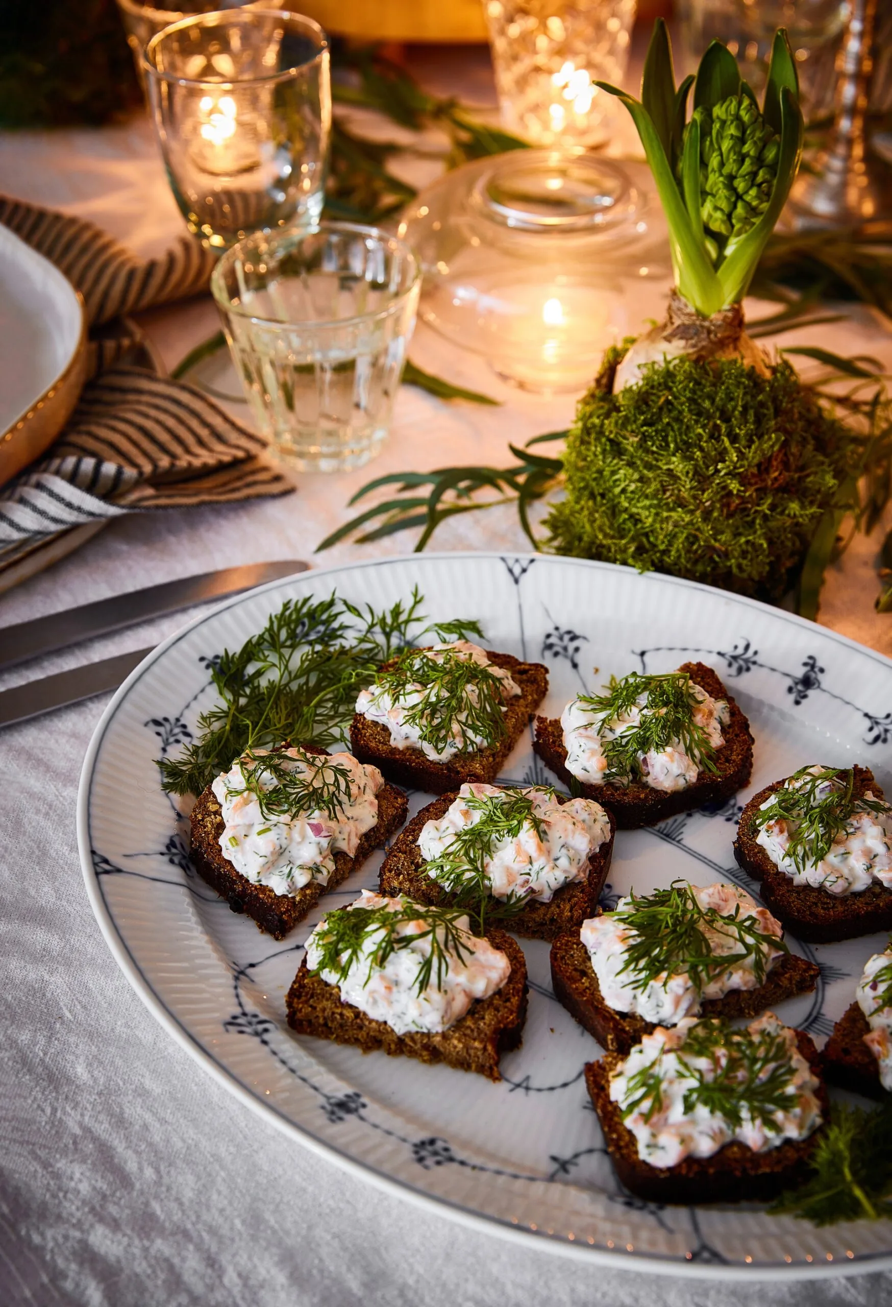 A plate of canapes on a candle-lit dining table