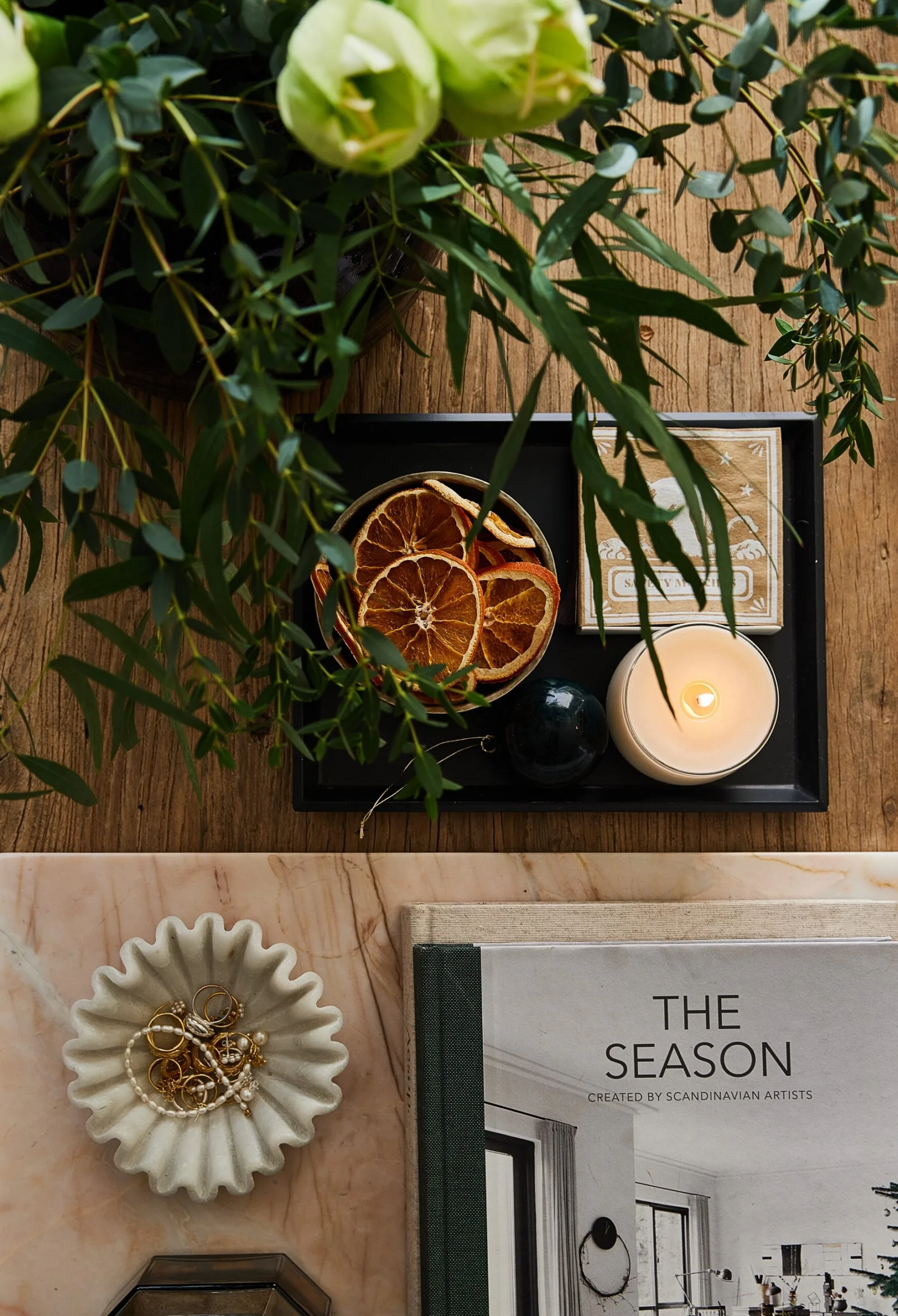 A coffee table topped with a candle and interior design books
